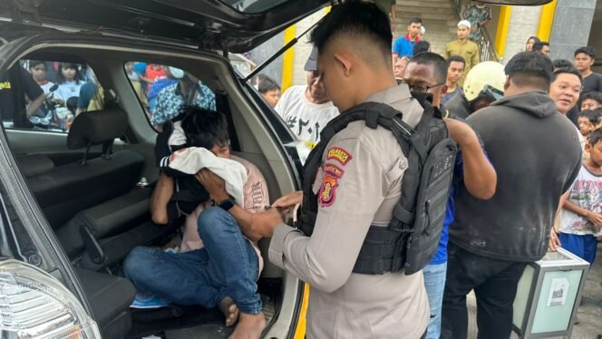 
					Foto : Pihak kepolisian mengamankan tersangka menggunakan mobil setelah diamankan oleh warga/ Foto: HO