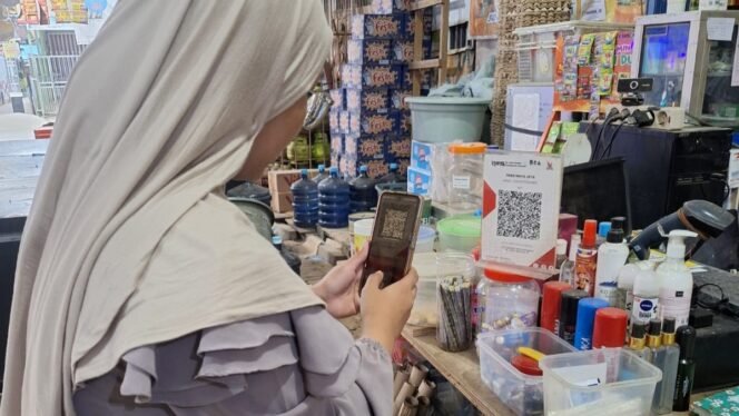 
					Konsumen membayar minuman yang dibelinya melalui ponsel dengan menggunakan fitur Quick Reponse Code Indonesian Standard (QRIS) di Toko Maya Jaya, Kota Samarinda, Kalimantan Timur, Jumat (20/12/2024)/Foto: Fasenews.id